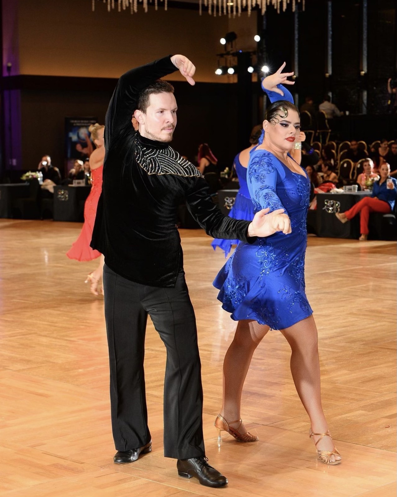 Ryan Smith performing a ballroom dance routine with a partner in blue