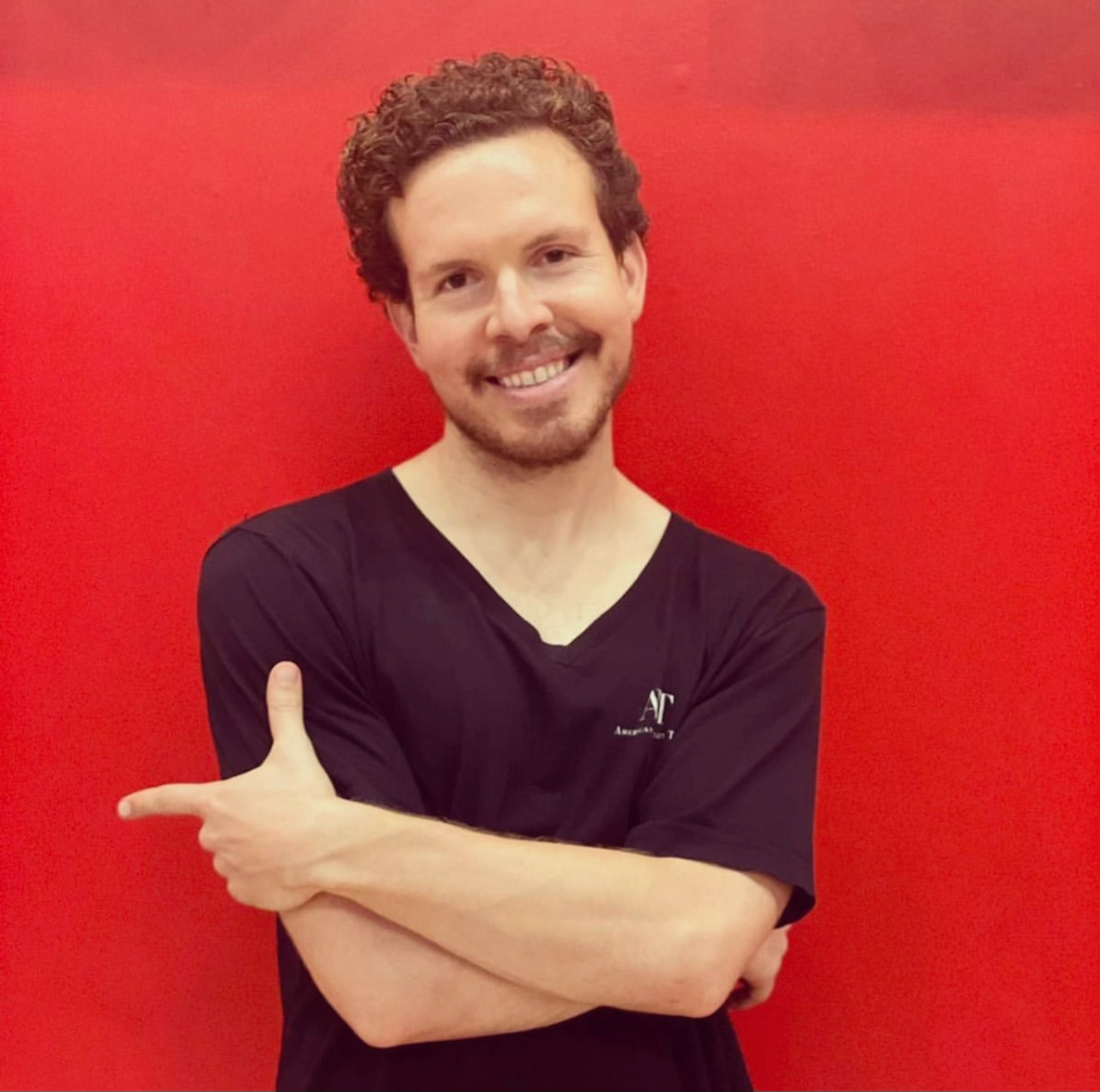 Ryan Smith smiling against a vivid red background