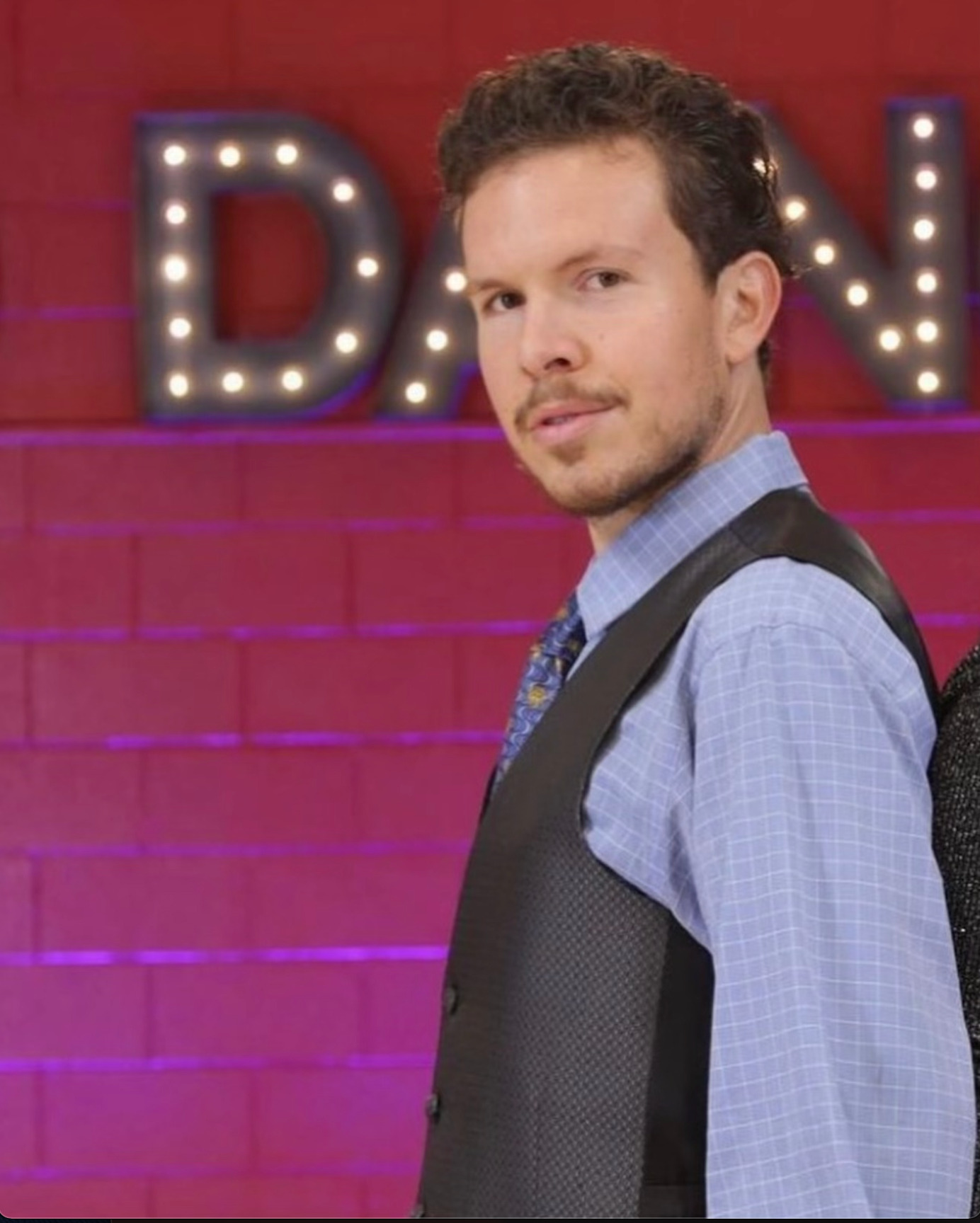 Portrait of Ryan Smith in a vest at a dance venue
